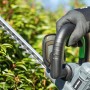 Akumulatorowe nożyce do żywopłotu LUX A-HS-20/52-24 z akumulatorem i ładowarką w użyciu.