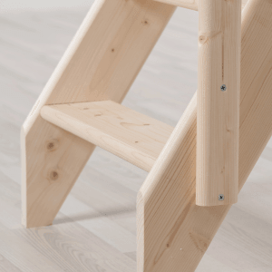 Zbliżenie schodów Dolle Schwerin z drewna świerkowego, nieobrobionego, z pełnymi stopniami.