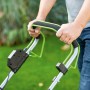 Zbliżenie: Dłonie na uchwycie akumulatorowej kosiarki LUX. Ergonomiczna i wygodna.
