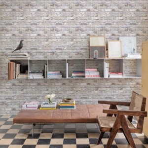 Tapeta dekoracyjna imitująca jasną ścianę z cegieł w salonie.