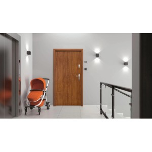 Brązowe drzwi zewnętrzne w nowoczesnym korytarzu z wózkiem i windą.