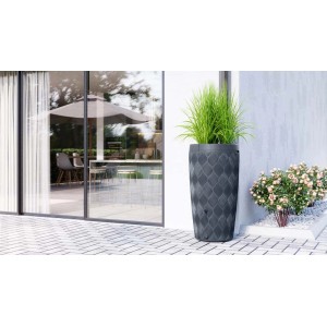 Szary zbiornik na deszczówkę t.b.t. o wyglądzie kamienia z roślinami przed nowoczesnym domem.