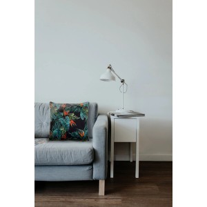 Dekoracyjna poduszka t.b.t. z tropikalnym wzorem roślinnym na szarej sofie.