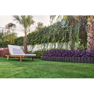 Szara obrzeże rabaty/obrzeże trawnika w ogrodzie, z leżakiem i roślinami. Kategoria: Obrzeża trawnikowe.