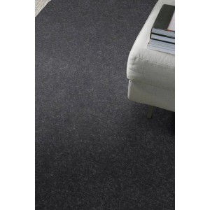 Ciemnoszara wykładzina dywanowa t.b.t. na metry, z jasną sofą w tle.