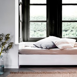 Przytulne miejsce do siedzenia przy oknie z poduszkami i dywanem.