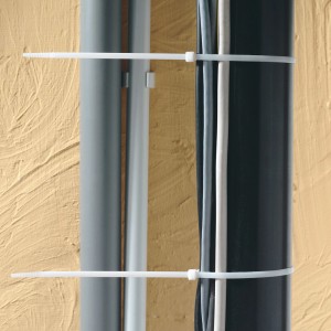 Białe opaski kablowe (368 mm) do łączenia kabli i przewodów na ścianie.