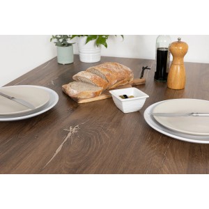 Stół z folią imitującą drewno, nakryty chlebem, oliwkami i naczyniami.