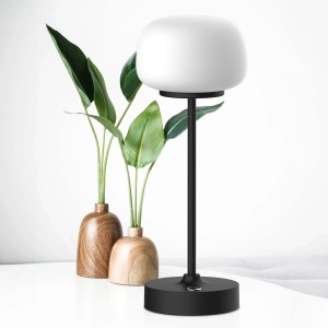 Dekoracyjna lampa stołowa t.b.t. z białym kloszem i czarną podstawą.