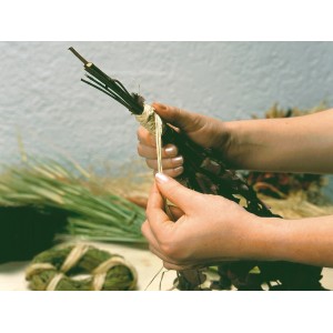 Ręce wiążą bukiet naturalną rafią. Naturalna rafia do dekoracji i prac ogrodowych.