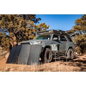 Panel słoneczny EcoFlow 400W z torbą w użyciu podczas biwakowania, ustawiony obok samochodu.