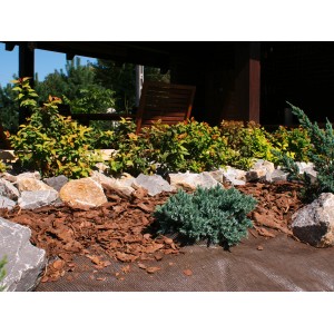 Ogród z folią/włókniną, kamieniami, roślinami i ściółką. Pokrycie gleby do ogrodnictwa.