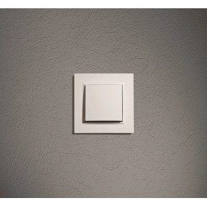 Biały włącznik światła t.b.t. na szarej ścianie. Włącznik do światła i prądu.