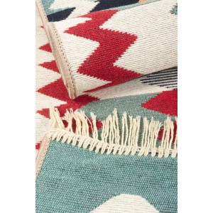 Zbliżenie dywanu z krótkim włosiem t.b.t. z frędzlami i geometrycznymi wzorami.