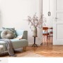 Salon z miętową zieloną farbą na ścianach. Elementy dekoracyjne, takie jak sofa, stół i wazon.