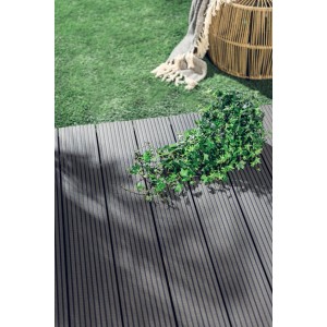 Szare deski tarasowe t.b.t. na trawie z bluszczem. Idealne do użytku zewnętrznego.