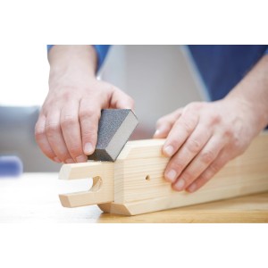 Szlifowanie drewna materiałem ściernym. Klocek ścierny używany do obróbki drewna.