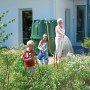 Garantia Zysterna Herkules 1600 l w ogrodzie z bawiącymi się dziećmi i kobietą podlewającą.