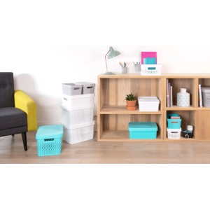 Różne pojemniki do przechowywania t.b.t. w kolorze białym, szarym i turkusowym w salonie.