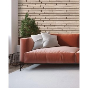 Aranżacja ściany z jasnymi płytkami klinkierowymi t.b.t. za sofą.