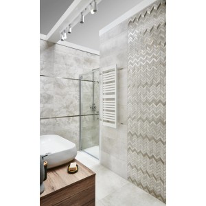 Łazienka z płytkami podłogowymi t.b.t. w kolorze beżowym i szarym, wzór jodełki na ścianie.