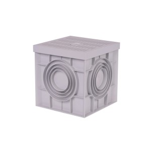 Szary plastikowy korpus odpływowy t.b.t. o kwadratowym kształcie z bocznymi tulejami przyłączeniowymi.