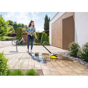 Kobieta czyści kamienne patio za pomocą myjki do powierzchni Kärcher T 5 T-Racer.