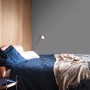 Sypialnia z szarą farbą do ścian (t.b.t.) i niebieską pościelą.