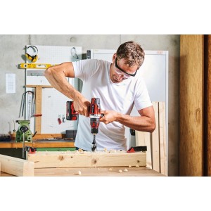 Wiertarko-wkrętarka udarowa akumulatorowa Einhell Power X-Change TE-CD 18/48 Li-i-Solo podczas wiercenia w drewnie.