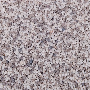 Zbliżenie tynku t.b.t. z małymi, jasnymi kamyczkami.