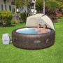 Bestway LAY-Z-SPA z osłoną przeciwsłoneczną w ogrodzie, dwie osoby relaksują się w jacuzzi.