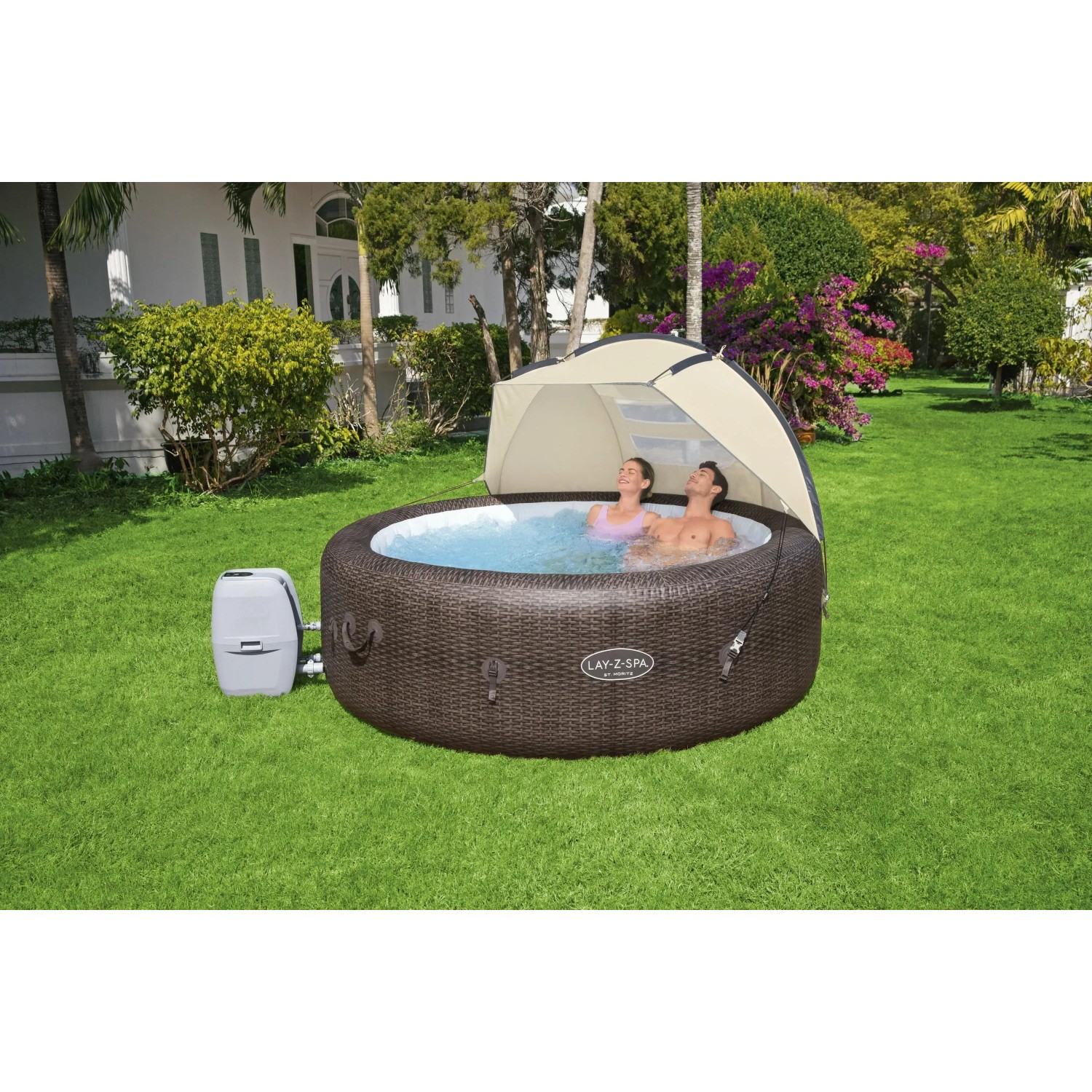 Bestway LAY-Z-SPA z osłoną przeciwsłoneczną w ogrodzie, dwie osoby relaksują się w jacuzzi.