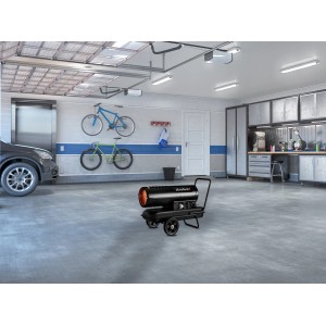 Czarna nagrzewnica t.b.t. na kółkach w garażu.