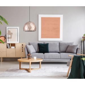 Nowoczesna lampa wisząca w kolorze różowego złota o geometrycznym wzorze nad salonem.
