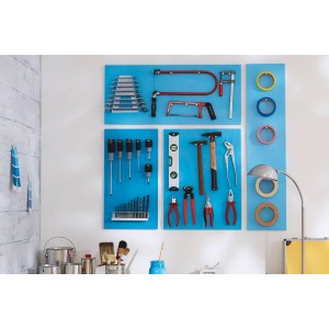 Ściana narzędziowa ze śrubokrętami, szczypcami, młotkiem, piłami i taśmą klejącą na niebieskim tle.