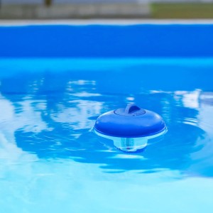 Niebieski pływak dozujący w basenie do pielęgnacji wody.