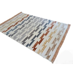 Wzorzysty dywan z krótkim włosiem i frędzlami w kolorze białym, szarym, niebieskim i brązowym.