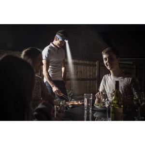 Mężczyzna grilluje z czołówką Energizer Vision. Latarka z jasnym światłem na wieczór.