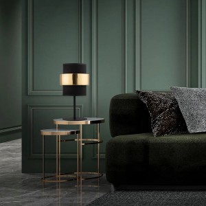 Dekoracyjna lampa stołowa z czarnym abażurem i złotym pierścieniem na stoliku bocznym.