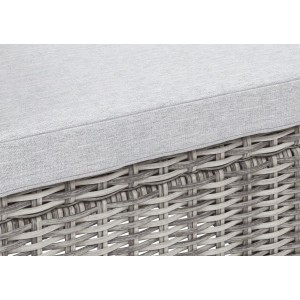 Zbliżenie: Szara poduszka i rattanowy splot zestawu mebli ogrodowych.