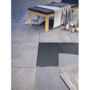 Układanie szarych płytek podłogowych na zewnątrz za pomocą kleju do płytek. Projekt tarasu.