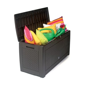 Otwarty, brązowy pojemnik na poduszki t.b.t. wypełniony poduszkami i konewką.