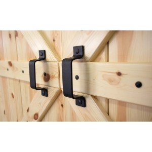 Czarne klamki na drewnianych drzwiach w stylu stodoły.