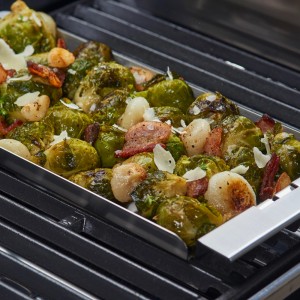 Brukselka z boczkiem i serem w naczyniu na grillu. Akcesoria do grilla.