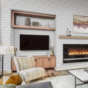 Salon z białą ścianą z kamienia dekoracyjnego t.b.t. i kominkiem.