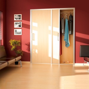 Szafa z drzwiami przesuwnymi z jasnymi drewnianymi frontami i srebrnymi uchwytami. Kategoria: Prowadnice.