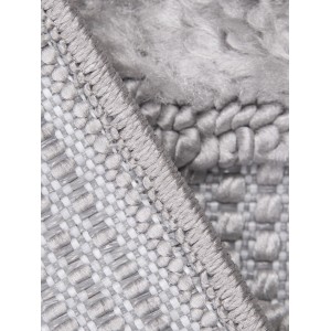 Zbliżenie szarego dywanu z krótkim włosiem. Struktura i krawędź są dobrze widoczne.