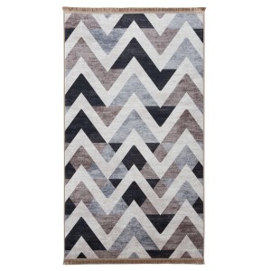 Nowoczesny dywan z krótkim włosiem we wzór zygzak w odcieniach szarości, brązu i czerni.