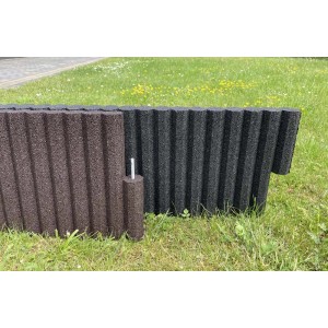 Brązowe i czarne obrzeże trawnikowe/rabatowe t.b.t. z gumy na trawie.