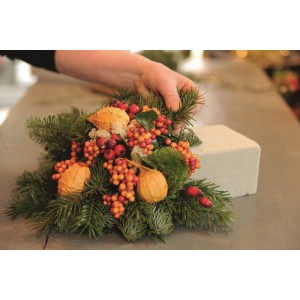 Sucha gąbka florystyczna do suchych kompozycji kwiatowych, ozdobiona jodłową zielenią i jagodami.